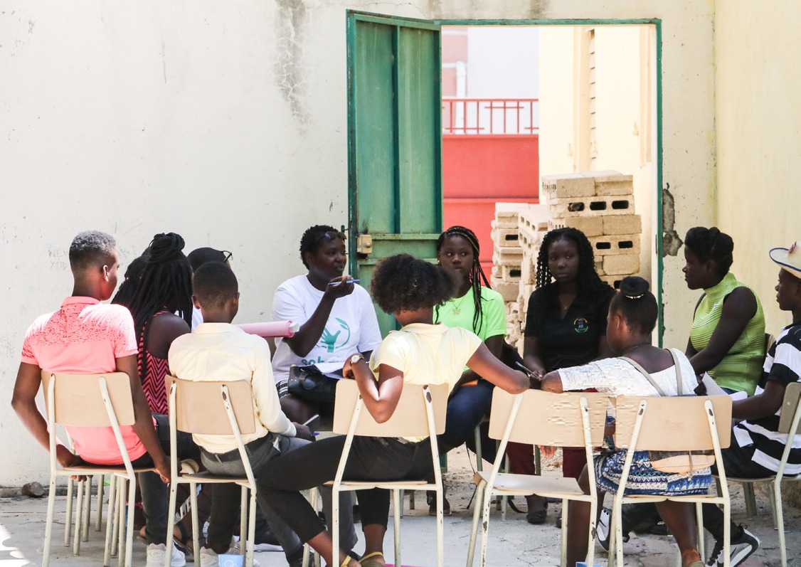 Jóvenes reunidos en ronda al aire libre durante un encuentro de Scholas en África