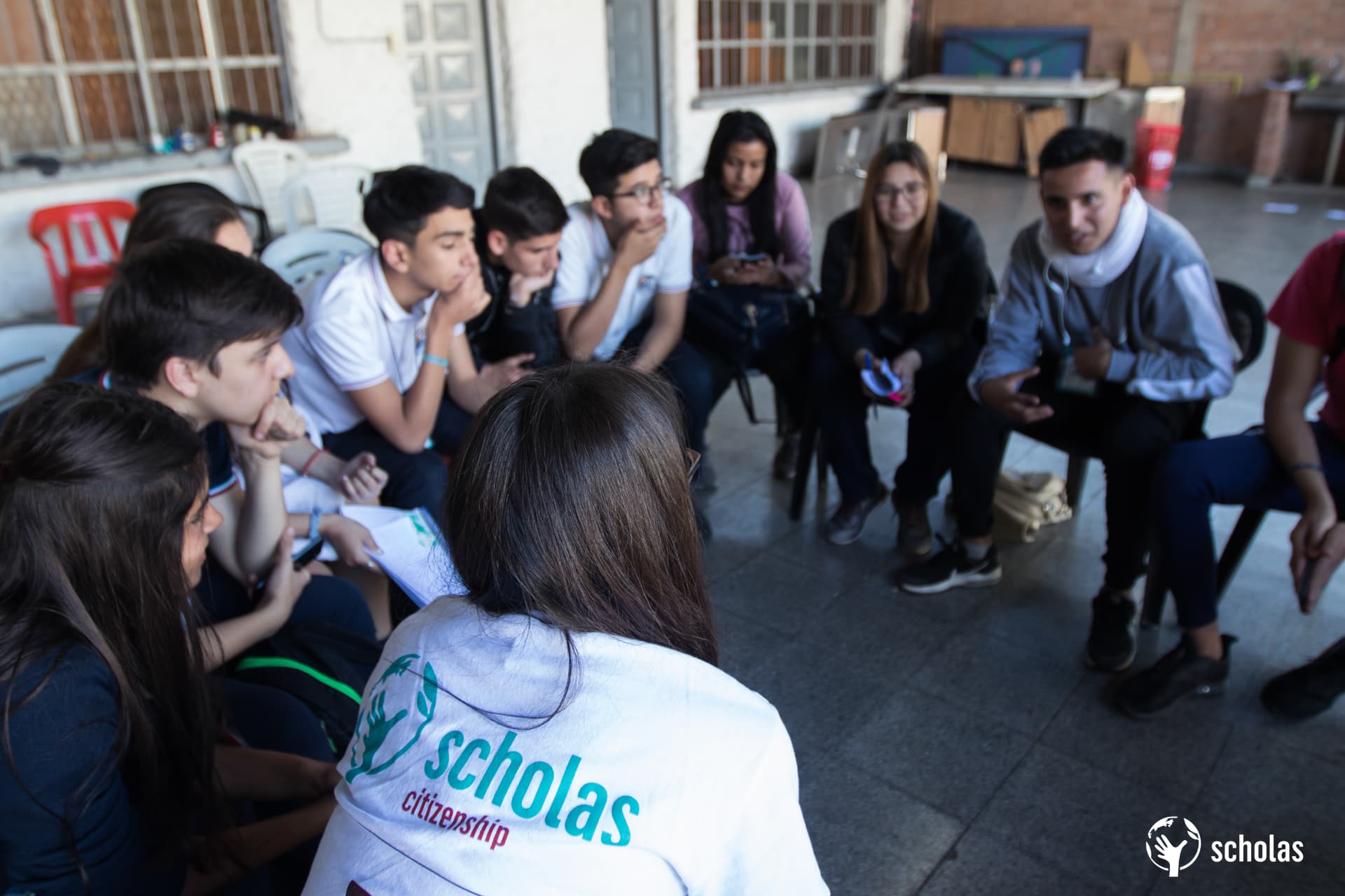 Jóvenes sentados en ronda escuchándose durante un encuentro de Scholas Ciudadanía