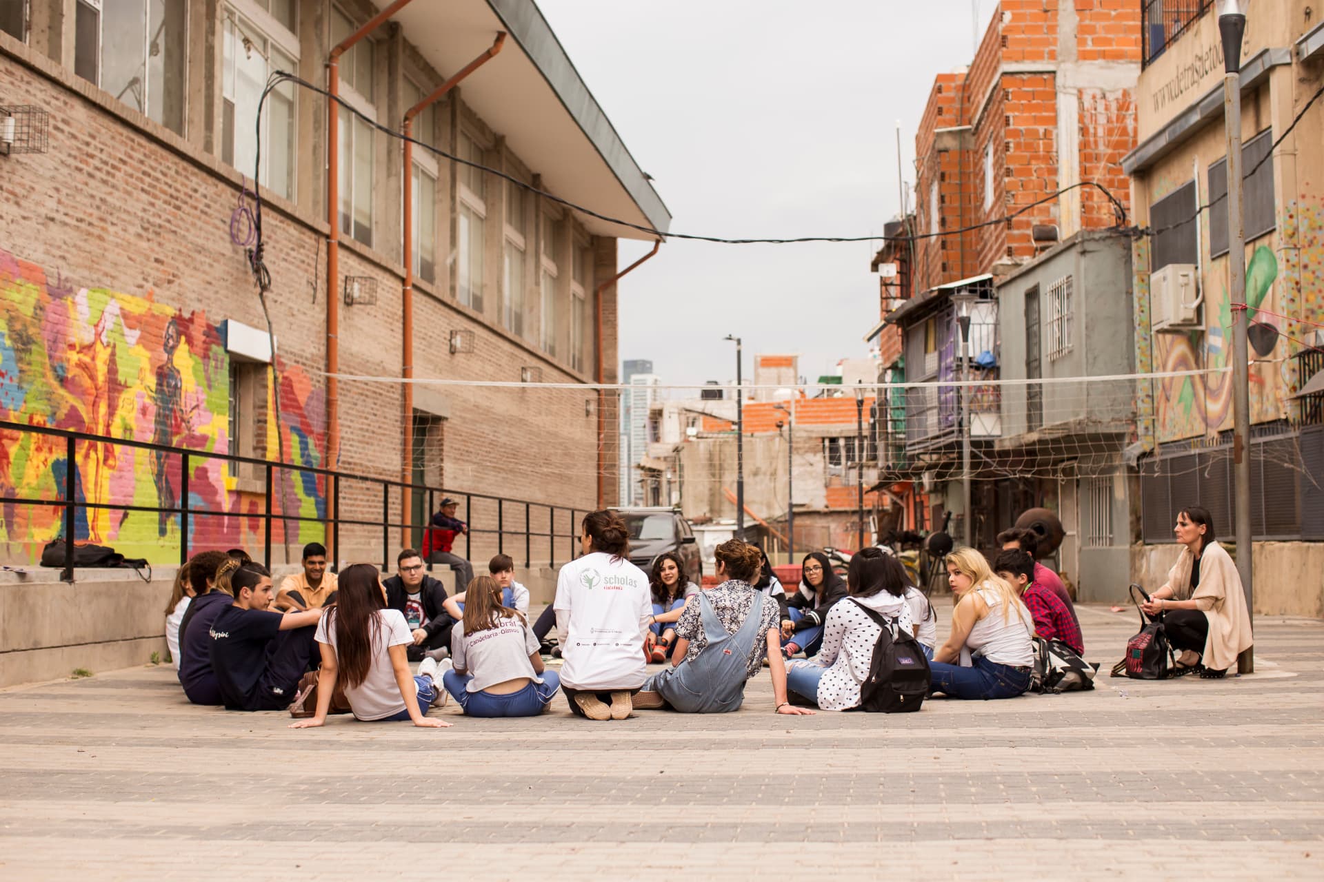 Ronda de jóvenes sentados en el suelo de un patio de barrio en Buenos Aires